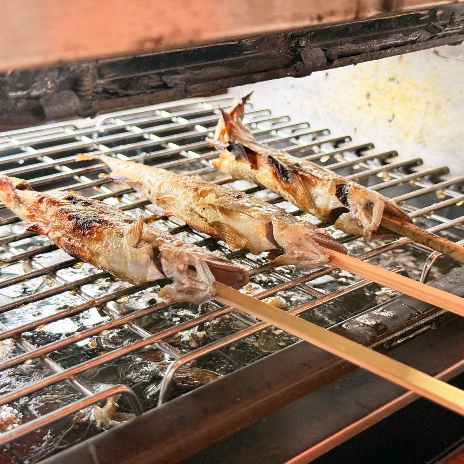 炭火で焼かれていく鮎